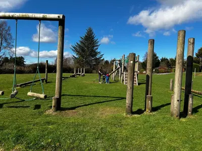 a park with a bunch of swings in a field at Log Cabin in Beautiful Snowdonia in Trawsfynydd