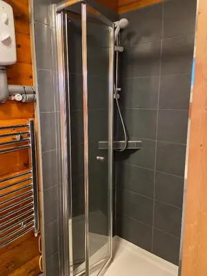 a shower with a glass door in a bathroom at Log Cabin in Beautiful Snowdonia in Trawsfynydd