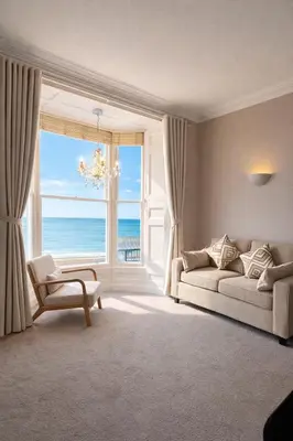 a living room with a couch and a view of the ocean at Swn Y Mor 3 Aberystwyth in Aberystwyth