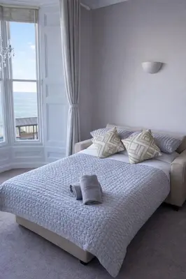 a bedroom with a bed with pillows and a window at Swn Y Mor 3 Aberystwyth in Aberystwyth