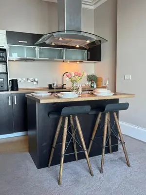 a kitchen with a large island with stools in it at Swn Y Mor 3 Aberystwyth in Aberystwyth