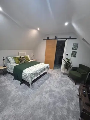 a bedroom with a bed and a couch and a television at Luxurious 5-Bedroom House Rental with Scenic Countryside Views in Hereford