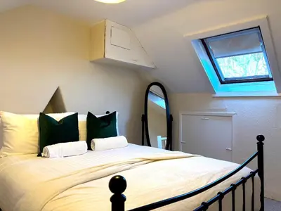 a bedroom with a large bed with green pillows at 2 bedroom house 12mins walk to town in Shrewsbury