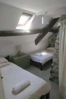 a bedroom with two beds in a room with a window at Welsh Hideaways in Pentre-briwnant