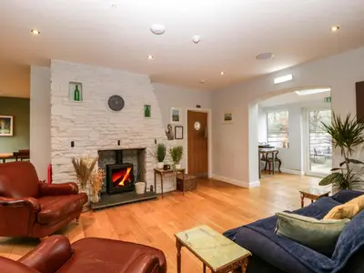a living room with a stone fireplace and furniture at The Swan in Hereford