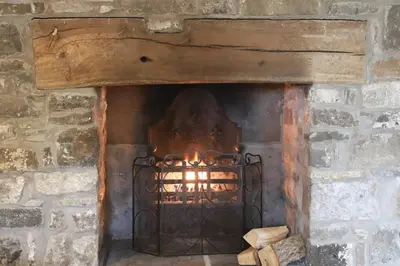 a brick oven with a fire in it at Abbey Cottages- Heron House in Talley