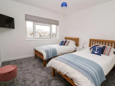 a bedroom with two beds and a window at Ty Melyn in Aberystwyth