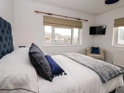 a bedroom with a bed with two pillows and a television at Ty Melyn in Aberystwyth