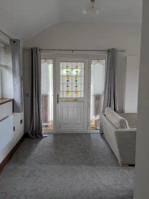 a living room with a couch and a glass door at Tanyfford Lodge, Abermule, Mid Wales, SY15 6NT in Abermule