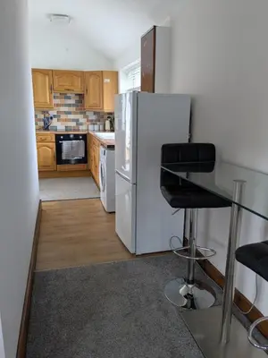 a kitchen with a white refrigerator and a stool at Tanyfford Lodge, Abermule, Mid Wales, SY15 6NT in Abermule