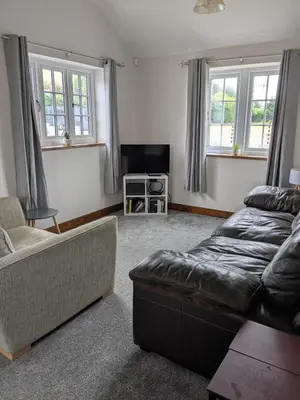 a living room with a couch and a tv at Tanyfford Lodge, Abermule, Mid Wales, SY15 6NT in Abermule