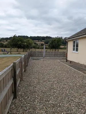 a fence next to a house and a field at Tanyfford Lodge, Abermule, Mid Wales, SY15 6NT in Abermule