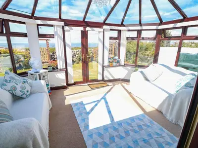 a living room with a white couch and windows at Goetra in Harlech