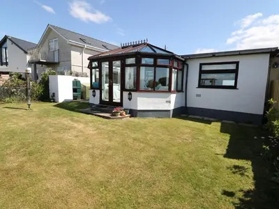 a house with a conservatory in a yard at Goetra in Harlech