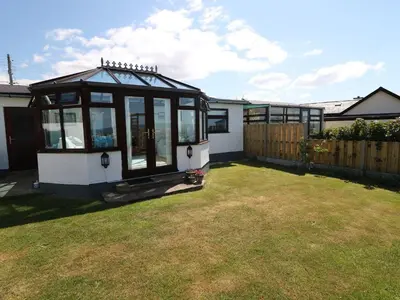 a small greenhouse in the backyard of a house at Goetra in Harlech
