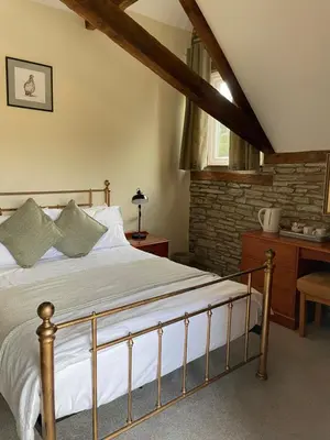 a bedroom with a bed and a brick wall at The Coach House Inn in Shobdon