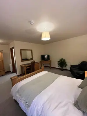 a bedroom with a large white bed and a television at The Coach House Inn in Shobdon