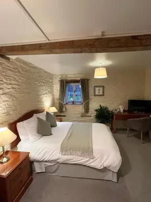 a bedroom with a large white bed in a room at The Coach House Inn in Shobdon
