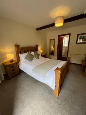 a bedroom with a large bed with white sheets and pillows at The Coach House Inn in Shobdon