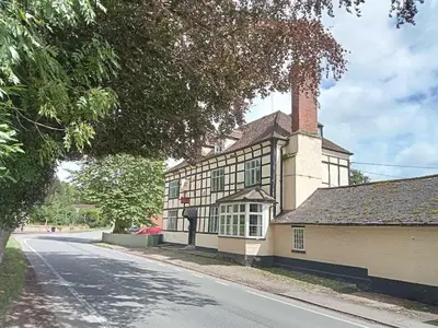 a large house with a chimney on the side of a street at The Coach House Inn in Shobdon