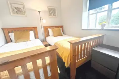 a bedroom with two beds and a window at 3 Bed Harbour-view Cottage Sleeps 6 - Dog Friendly in New Quay