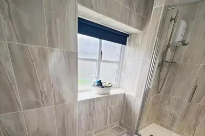 a bathroom with a shower and a window at 3 Bed Harbour-view Cottage Sleeps 6 - Dog Friendly in New Quay