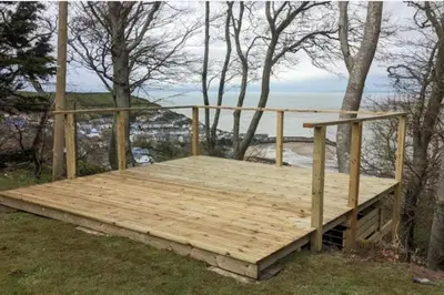 a wooden deck with a view of the ocean at 3 Bed Harbour-view Cottage Sleeps 6 - Dog Friendly in New Quay