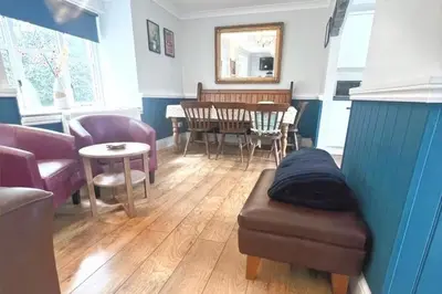 a living room with a couch and a table and chairs at 3 Bed Harbour-view Cottage Sleeps 6 - Dog Friendly in New Quay