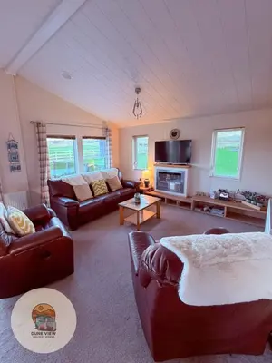 a living room with two couches and a couch at Dune View Chalet in Ynys-lâs Station