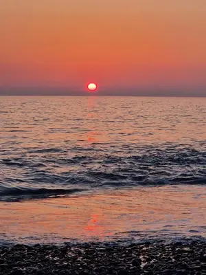 a sunset over the ocean with the sun setting at Brynowen Holiday Park Borth in Borth