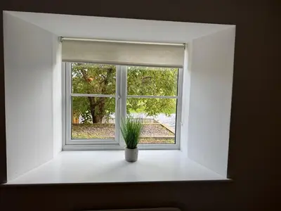 a window with a plant in a vase in front of it at Henllys Cottage in Corwen