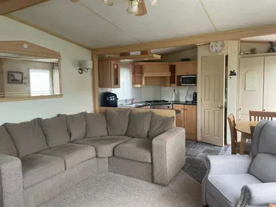 a living room with a couch and a kitchen at Family 3 Bedroom Caravan at Clarach Bay in Aberystwyth