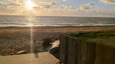 a view of a beach with the sun rising over the ocean at Family 3 Bedroom Caravan at Clarach Bay in Aberystwyth
