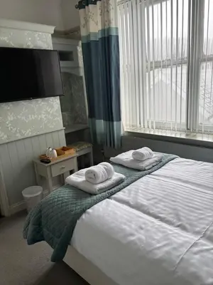 a bedroom with a bed with towels on it at Hazeldene Guest House in Aberaeron