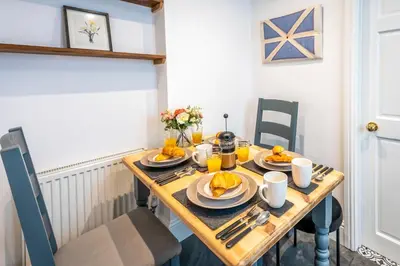 a wooden table with plates of food on it at Quaint home with log burner in peaceful cul-de-sac in Shrewsbury
