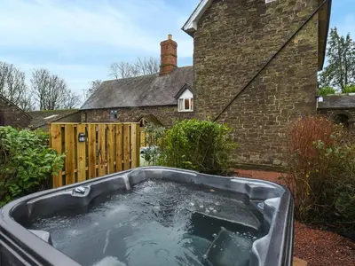 a bath tub in the yard of a house at Manor Farmhouse in Church Stretton