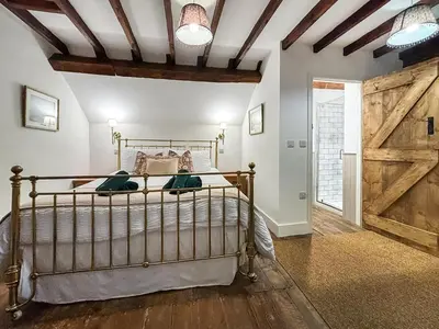 a bedroom with a bed and a wooden door at Manor Farmhouse in Church Stretton