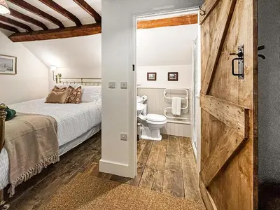 a bathroom with a bed and a toilet in a room at Manor Farmhouse in Church Stretton