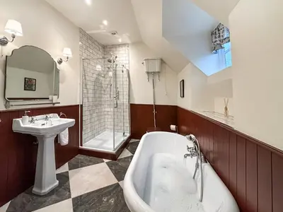 a bathroom with a tub and a sink and a shower at Manor Farmhouse in Church Stretton