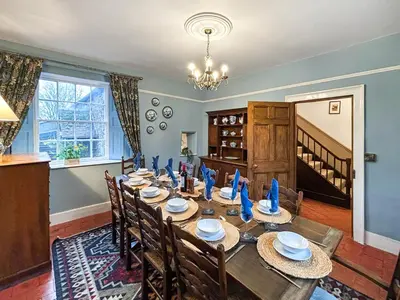 a dining room with a long table and chairs at Manor Farmhouse in Church Stretton