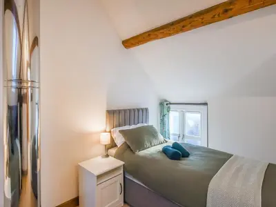 a small bedroom with a bed and a window at The Byre At Woodgate Farm in Church Stretton