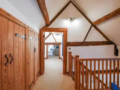 a hallway in a house with wooden beams at The Byre At Woodgate Farm in Church Stretton