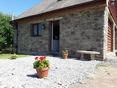 a stone house with two pots of flowers and a bench at Holiday Home Haus in Crickadarn mit Parkplatz und Bergblick by Interhome in Crickadarn