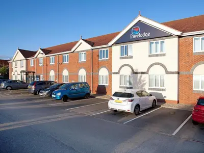 a hotel with cars parked in a parking lot at Travelodge Ludlow in Ludlow