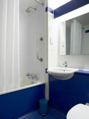 a blue and white bathroom with a sink and a mirror at Travelodge Ludlow in Ludlow