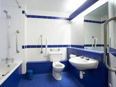 a blue and white bathroom with a toilet and a sink at Travelodge Ludlow Woofferton in Brimfield