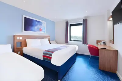 a hotel room with two beds and a tv at Travelodge Oswestry in Oswestry