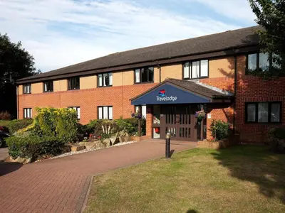 a red brick building with a blue awning on it at Travelodge Shrewsbury Bayston Hill in Meole Brace
