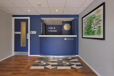 a hallway with a blue wall and a clock on the wall at Travelodge Shrewsbury Bayston Hill in Meole Brace