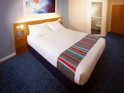 a bedroom with a large bed in a hotel room at Travelodge Shrewsbury Bayston Hill in Meole Brace